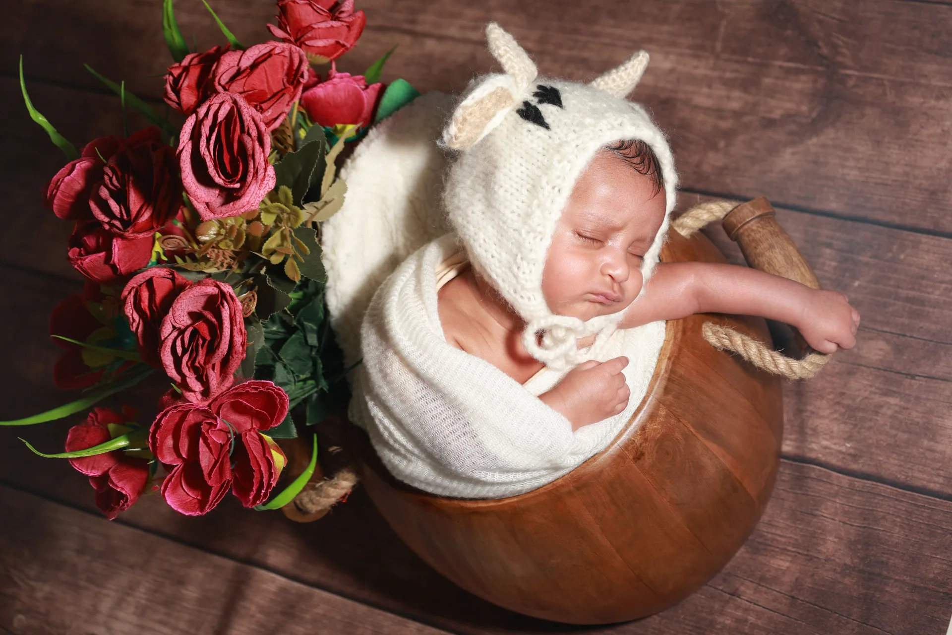 Bébé posé dans un panier fleuri avec accessoires